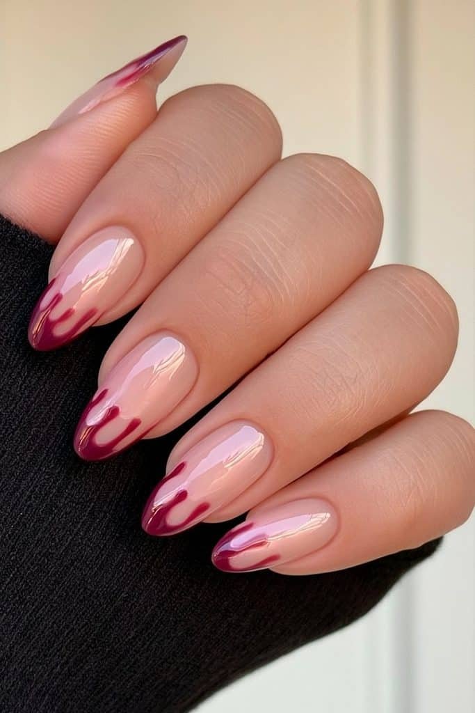 Short nude almond nails with dramatic deep red dripping French tips.