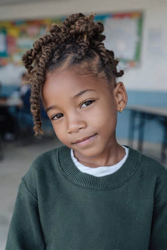 Young Black girl with a playful braided mohawk and neat side cornrows