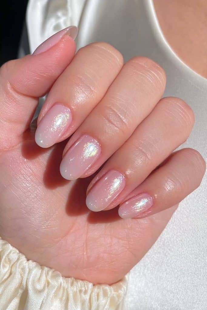 Short oval bridal nails in sheer milky pink with refined pearlescent glazed chrome.