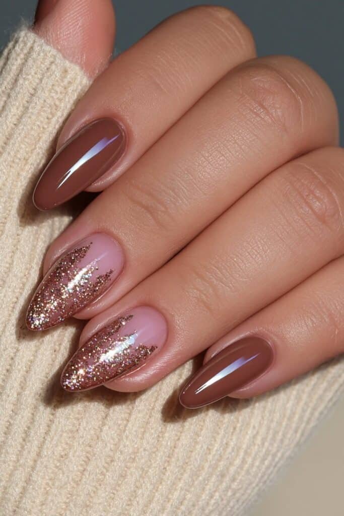 Warm brown almond nails with delicate gold glitter accents.