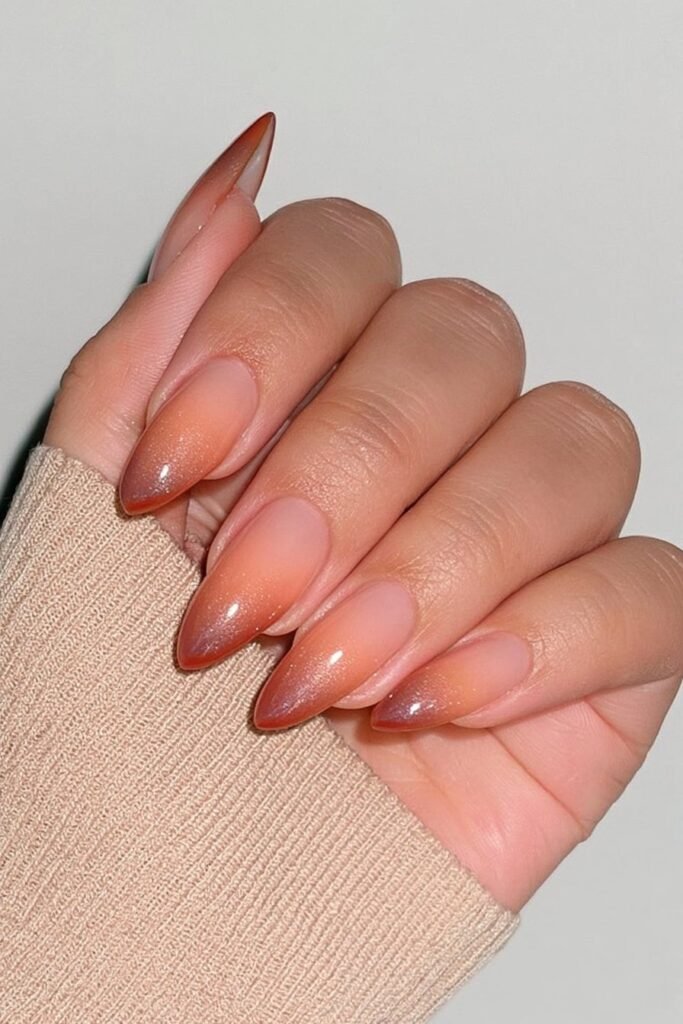Burnt orange almond nails with a seamless warm nude ombré.