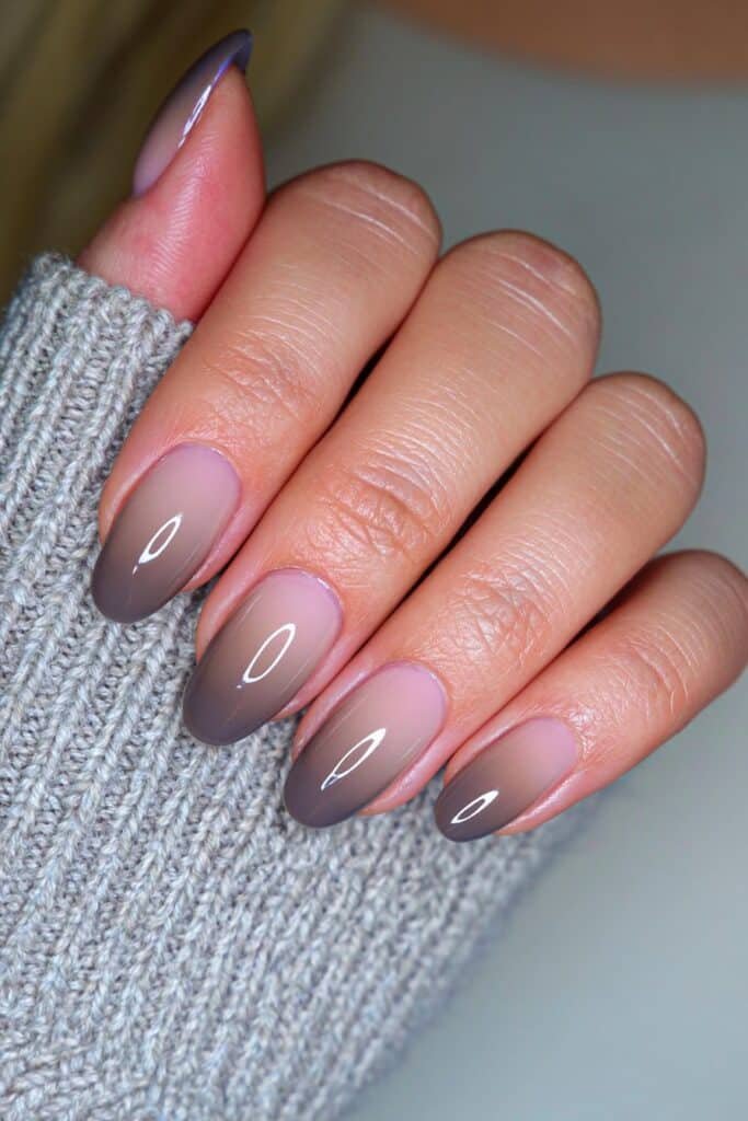 Short nails with a pale gray-to-charcoal glossy ombré.