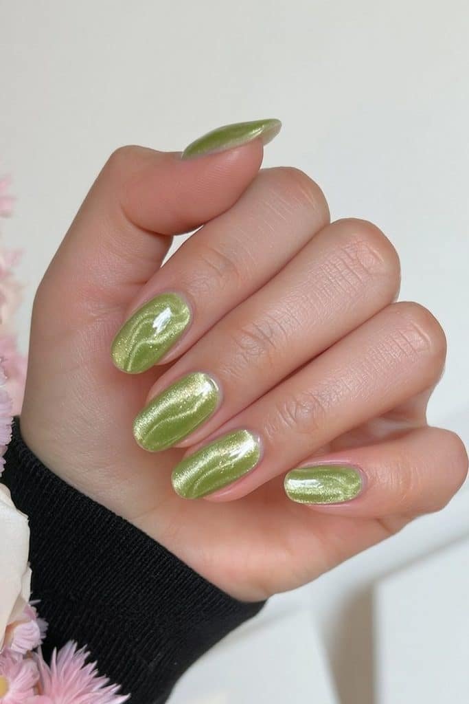 Short round nails in chartreuse velvet with darker green swirl accents.