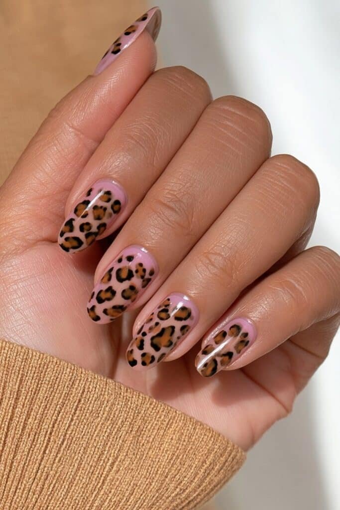 Short round brown nails with caramel, chocolate, and black cheetah print accents.