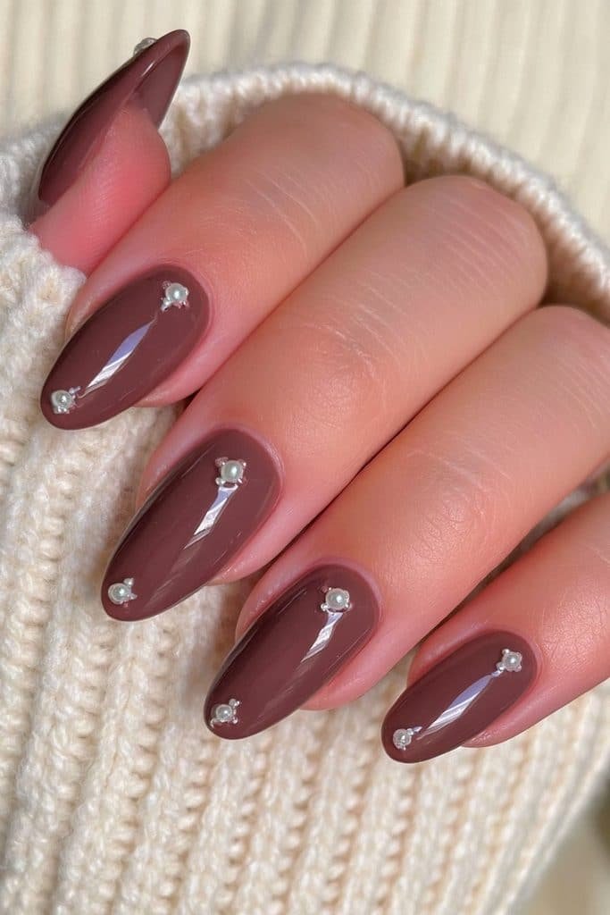 Short oval chocolate brown nails decorated with tiny ivory pearls