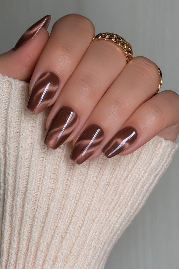 Short almond nails in chocolate velvet with delicate lighter brown swirls.
