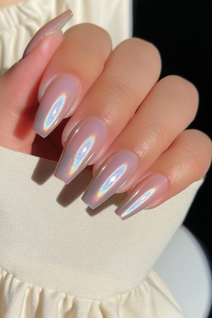Short warm champagne chrome nails with a luminous reflective finish.