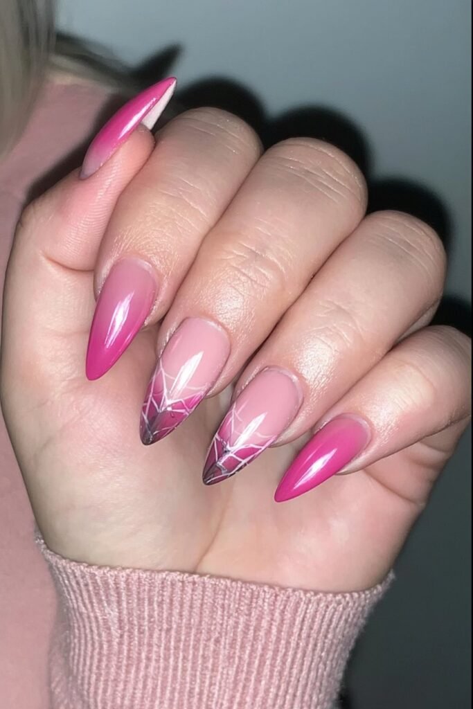 Baby pink nails with delicate white spider web designs.