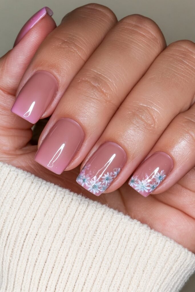 Short beige nails with delicate white daisy accents.