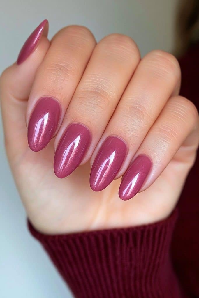 Short almond nails in translucent deep burgundy with a subtle glazed chrome reflection.