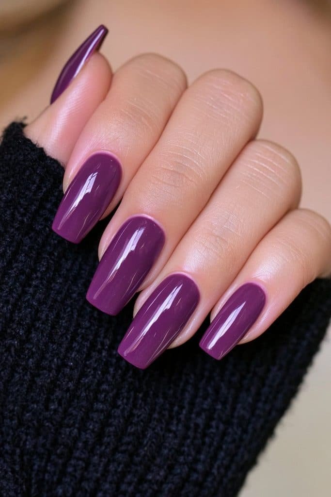 Short deep plum purple coffin nails with a sleek glossy Halloween finish.