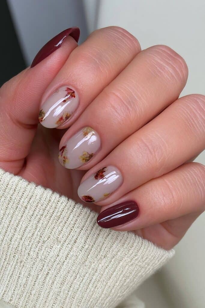 Short nude nails with delicate autumn leaf art.
