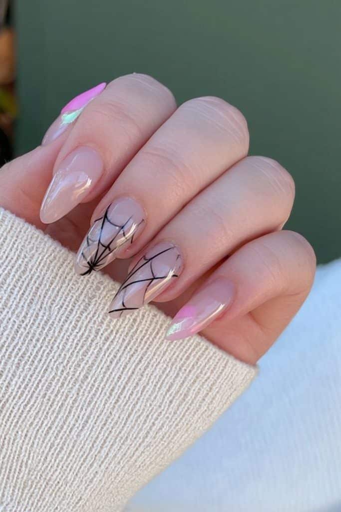 Short nude almond nails with delicate black spiderweb line-art accents.
