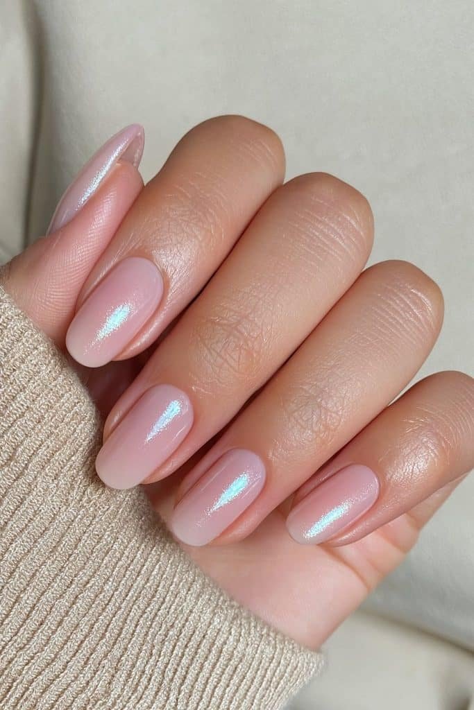 Short round nails in sheer natural nude with a subtle pearlescent glazed donut finish.