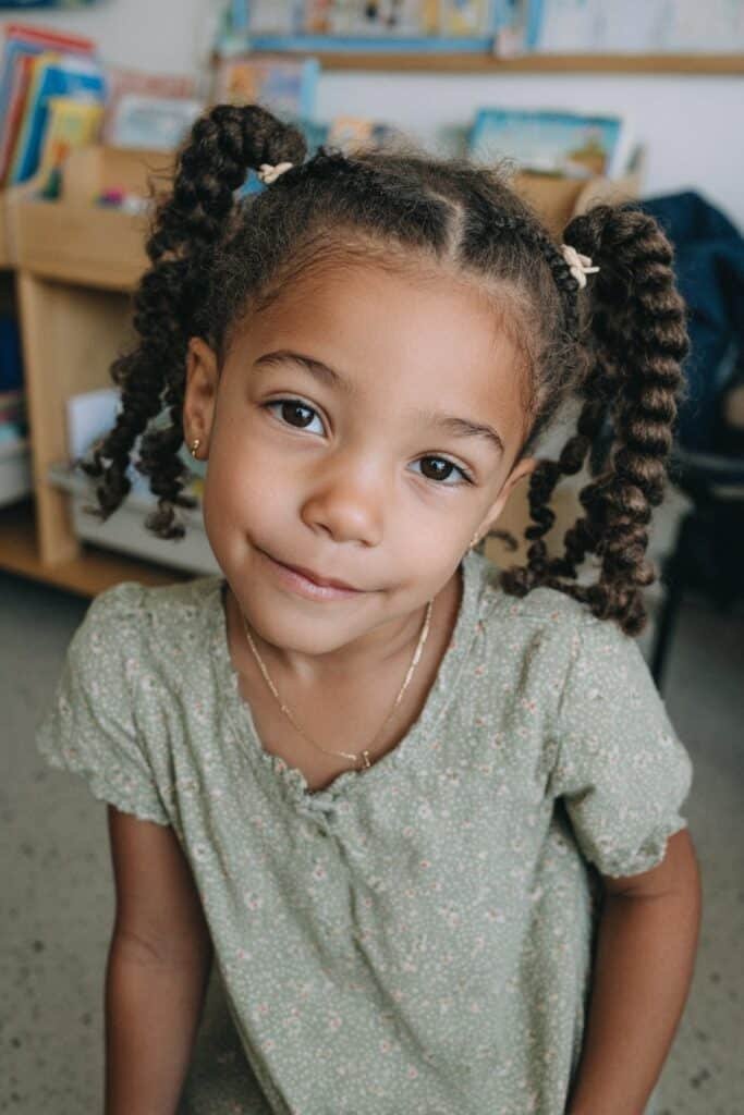 Black girl with French braid pigtails and pastel ribbons