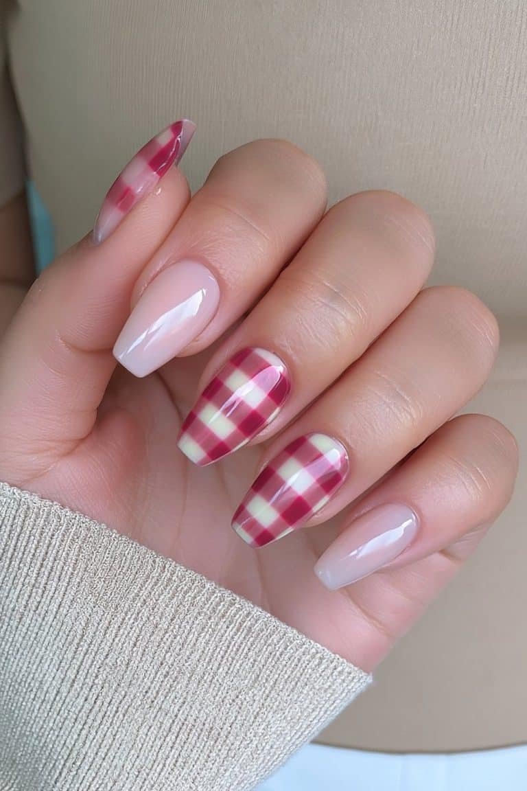 Short squoval Thanksgiving nails with creamy nude bases and cranberry gingham accents.