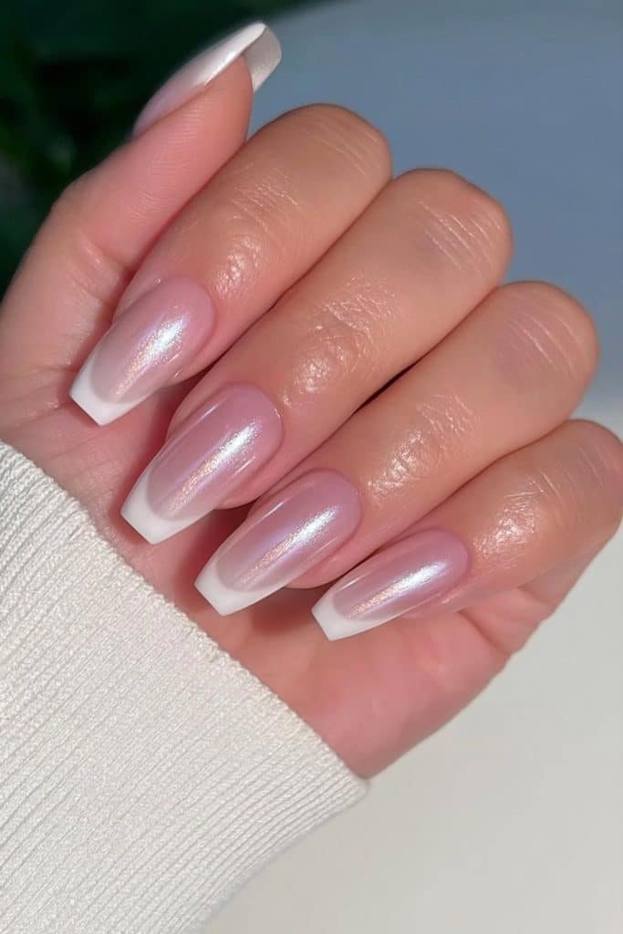 Short squoval nails with pinky nude bases, white French tips, and pearlescent glaze.