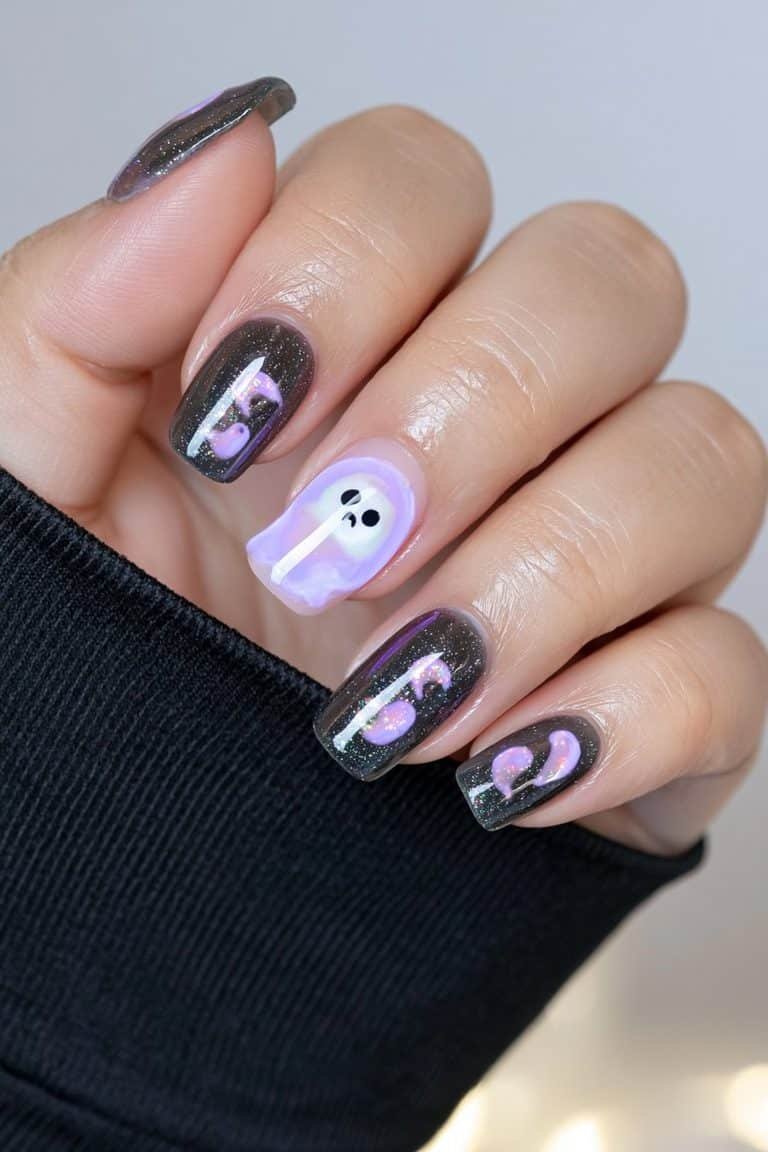 Short charcoal nails with a glowing ghost accent nail.