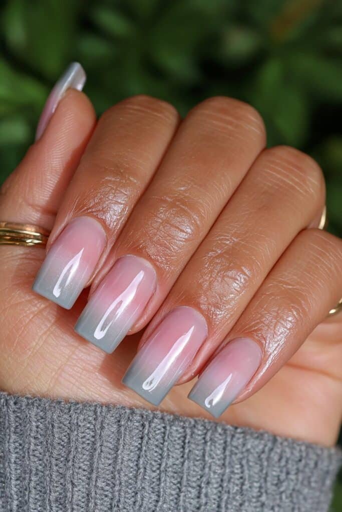 Short gray ombré nails with a glossy gradient finish.