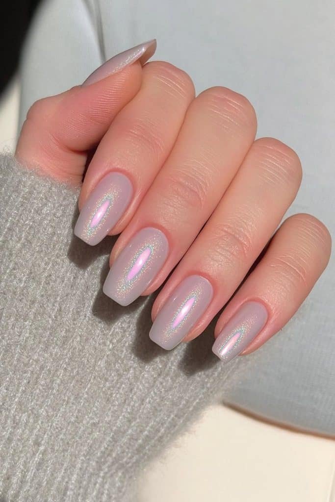 Short squoval nails in sheer cool gray with pearlescent glazed chrome and silver shimmer.