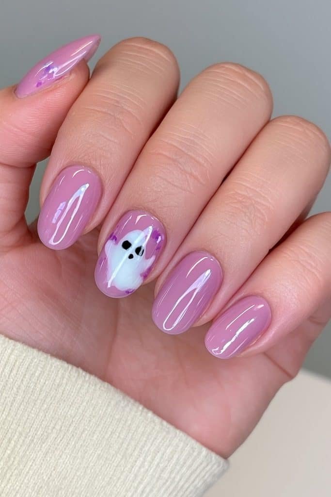 Short lavender nails with a tiny white ghost accent and purple details.