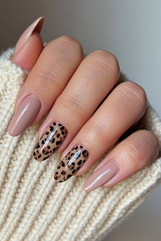 Short nude nails with a subtle leopard-print accent.