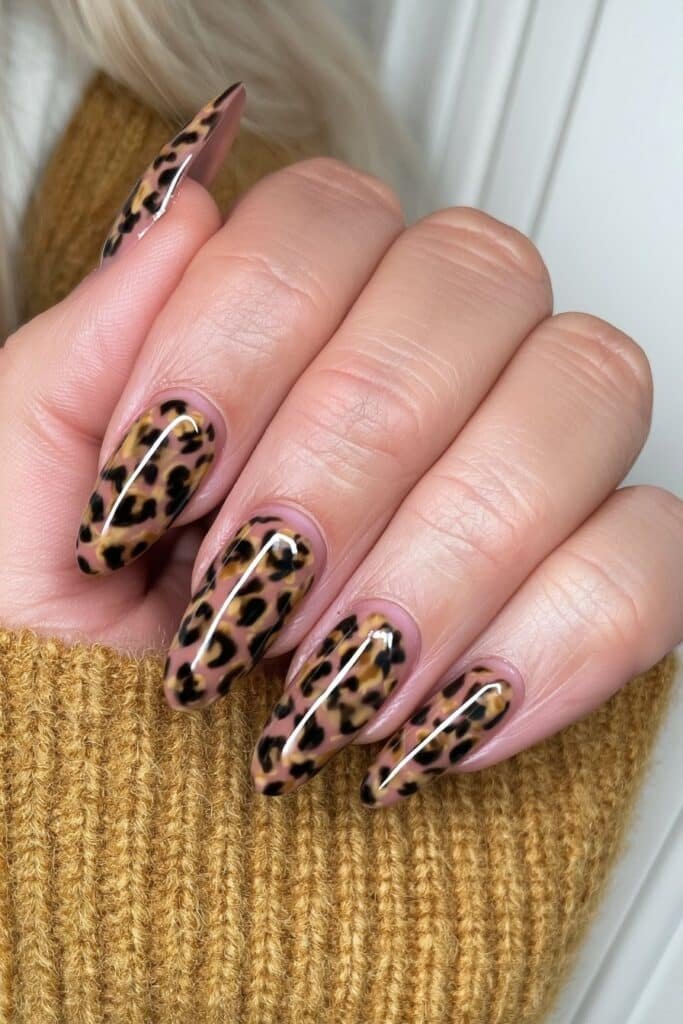 Warm nude nails with caramel and black leopard print accents.