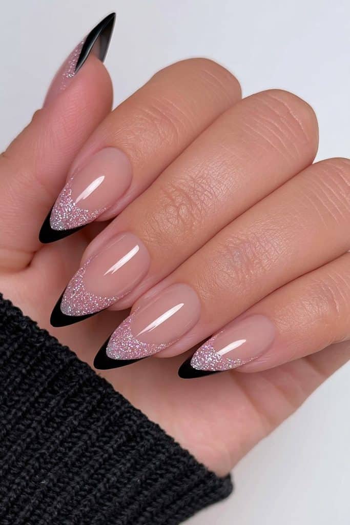 Short almond nails with matte black coffin-inspired French tips over sheer nude bases.