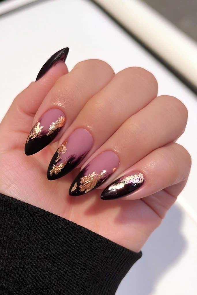Short matte black almond nails with luxurious metallic gold foil accents.