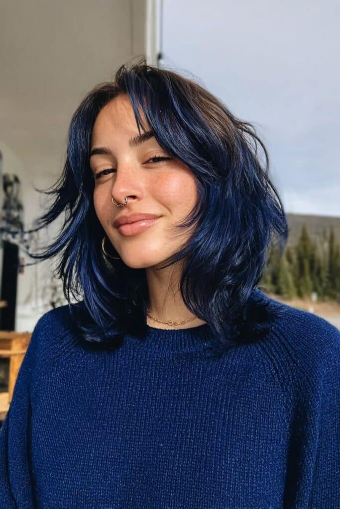 Medium close-up portrait featuring textured midnight blue choppy layered hair