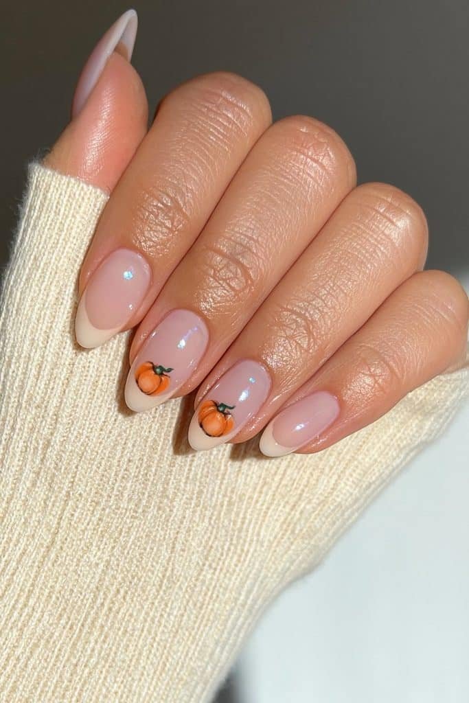 Short milky white almond nails with tiny orange pumpkins accent.