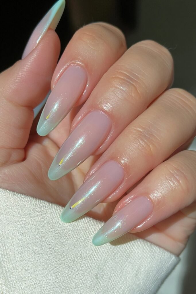 Mint glazed nails with tiny yellow pencil illustrations.
