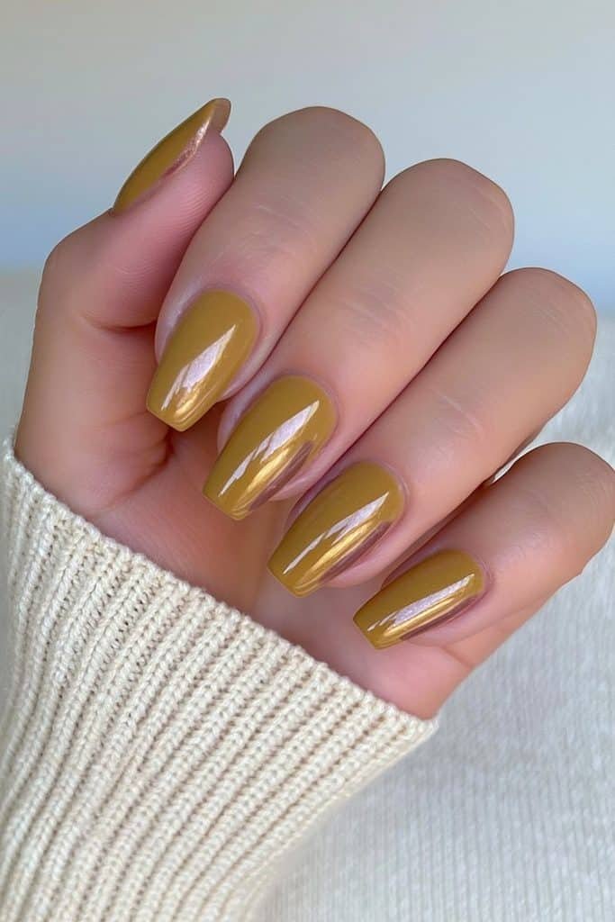 Short squoval Thanksgiving nails in muted mustard yellow with minimalist brown accents.