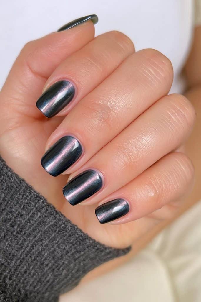Short black magnetic cat-eye nails with dimensional shimmer.