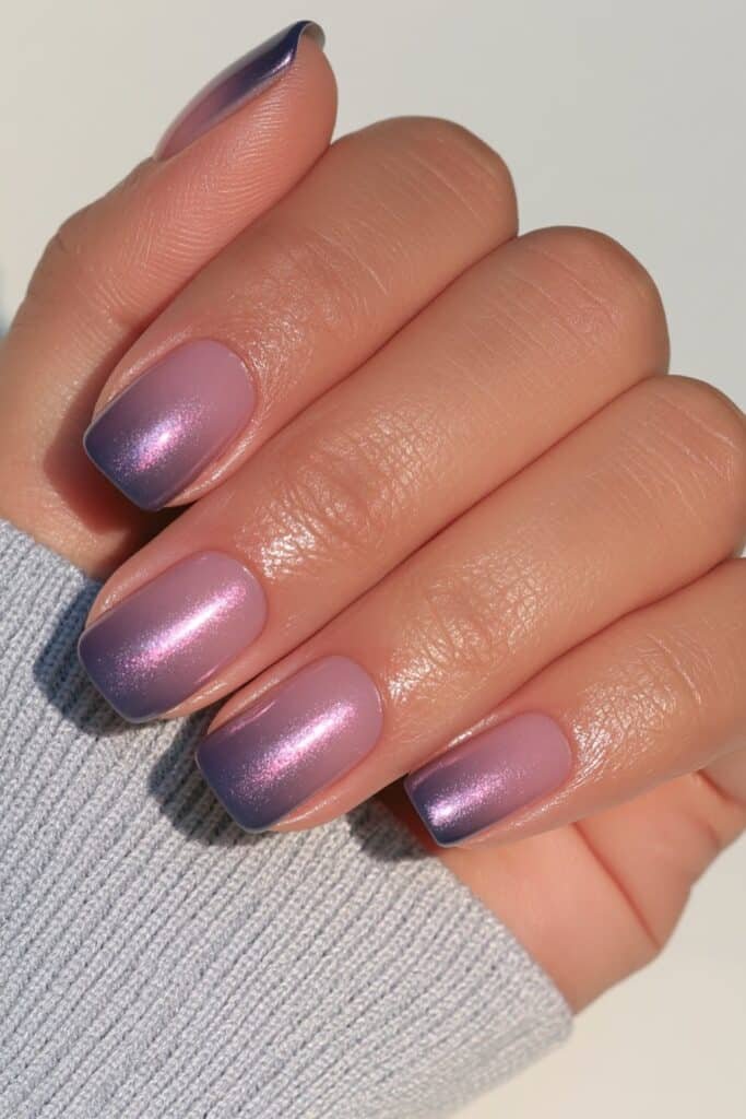 Short navy nails with a subtle glazed chrome finish.