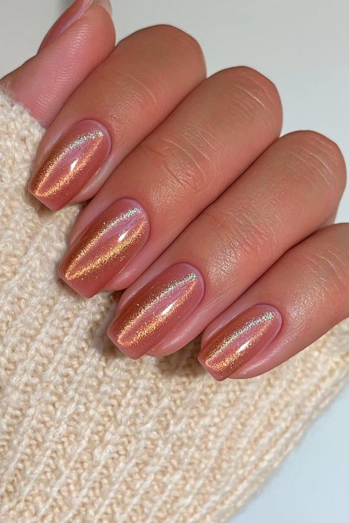 Short squoval nails in burnt orange velvet with glowing copper shimmer.