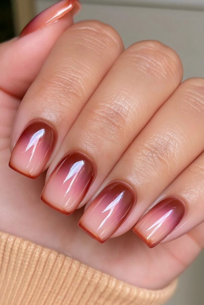 Short nails with orange to mahogany ombré colors.