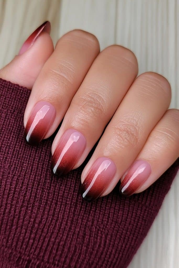 Short nails with a moody oxblood red and black ombre finish.