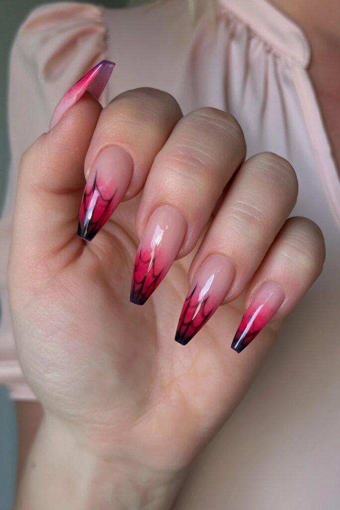 Pink ombré nails with fine black spider web lines.