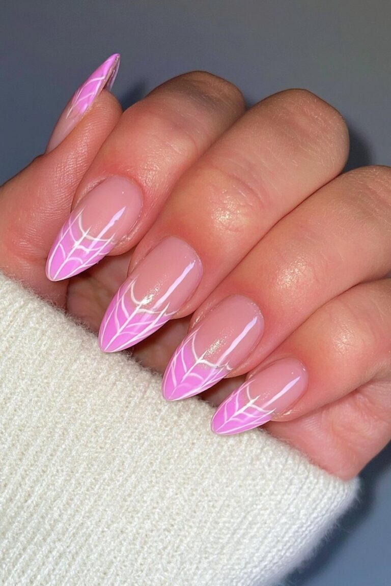 Pink and white nails with spider cobweb designs.