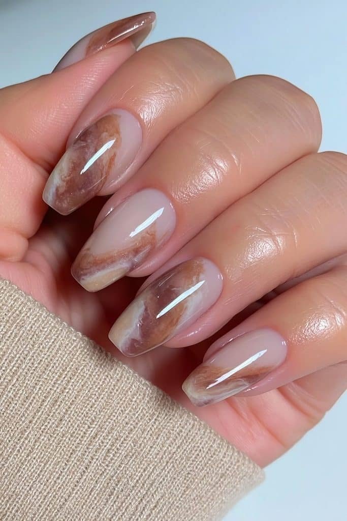 Short squoval Thanksgiving nails with pumpkin spice marble swirls in warm autumn colors.
