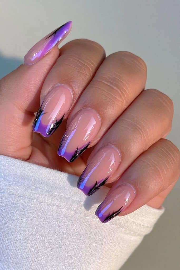 Short nude nails with rich purple French tips and tiny spider accent details.