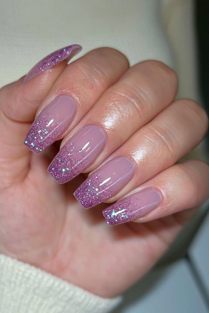 Short lavender nails with deep purple glitter fading from the tips.