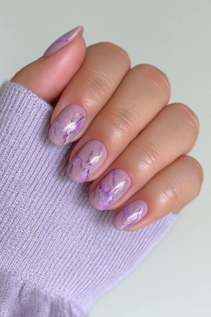 Short lilac nails with elegant purple and black marble veining.