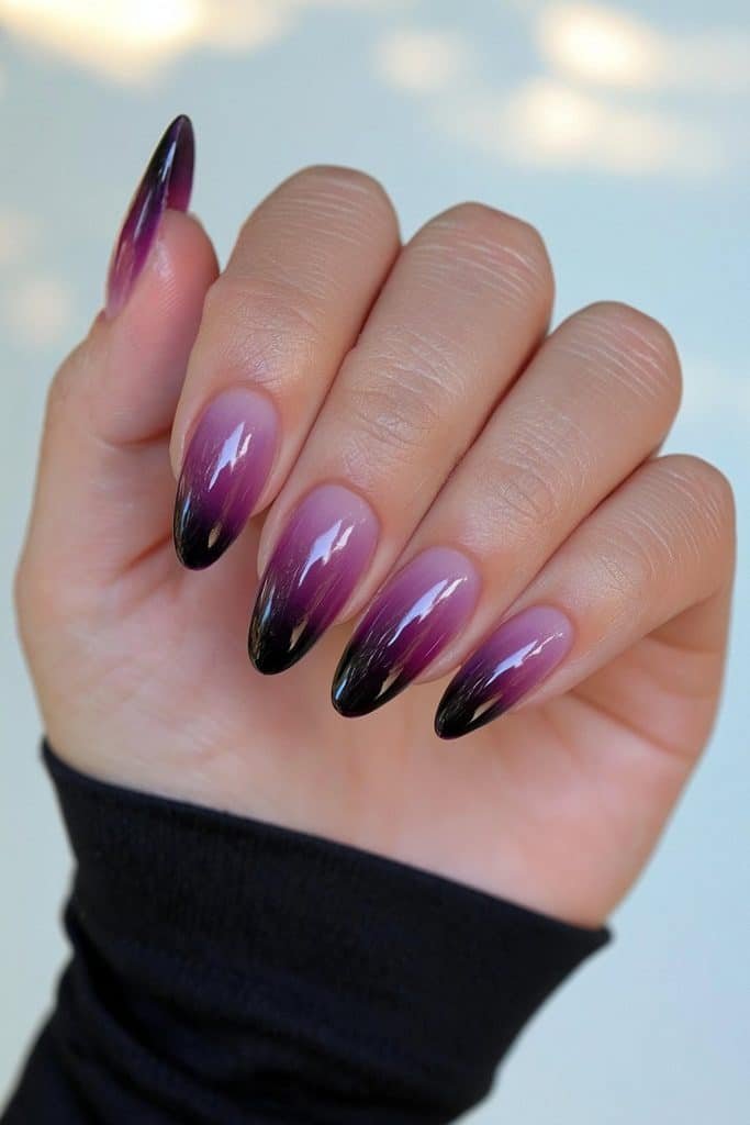 Short nails with a seamless deep purple-to-black ombré finish.