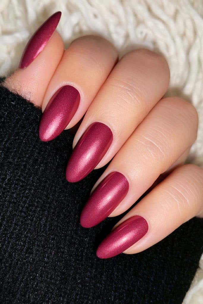 Short almond nails in reflective blood-red chrome with vampire-inspired shine.