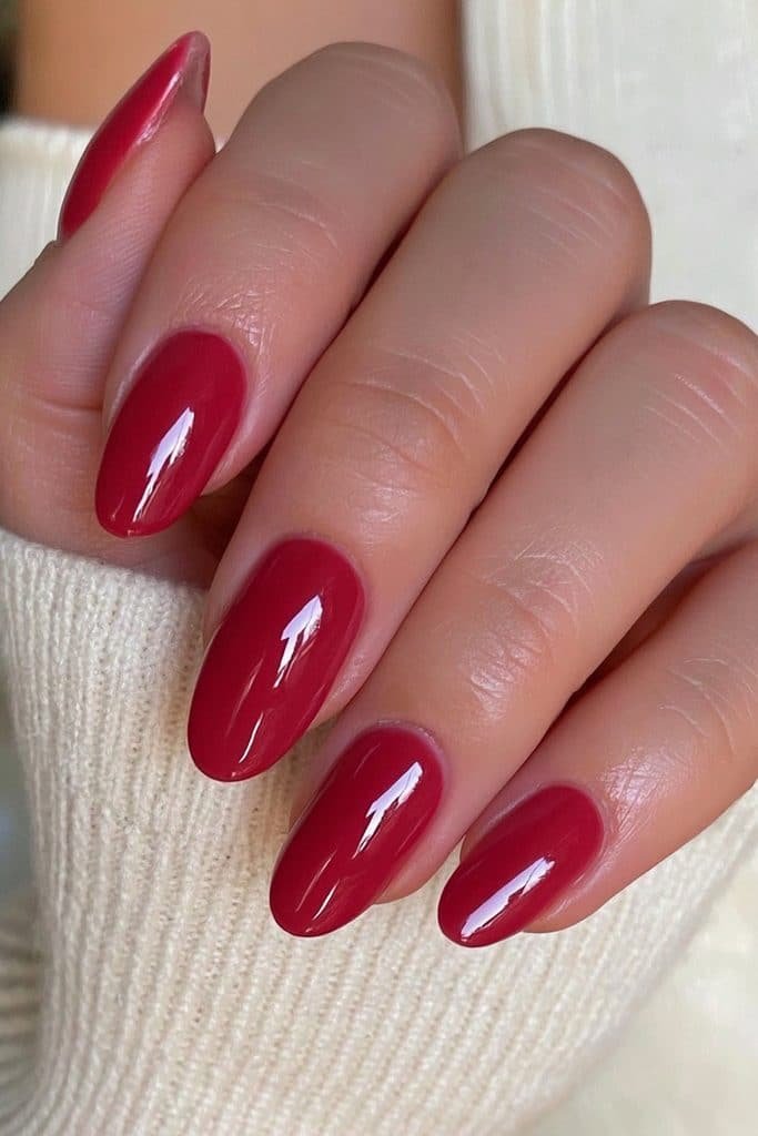 Short almond nails in rich classic red with a clean mirror-gloss finish.
