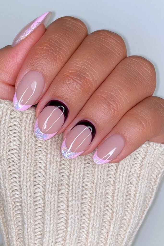 Short nude almond nails with black current reverse French tips.