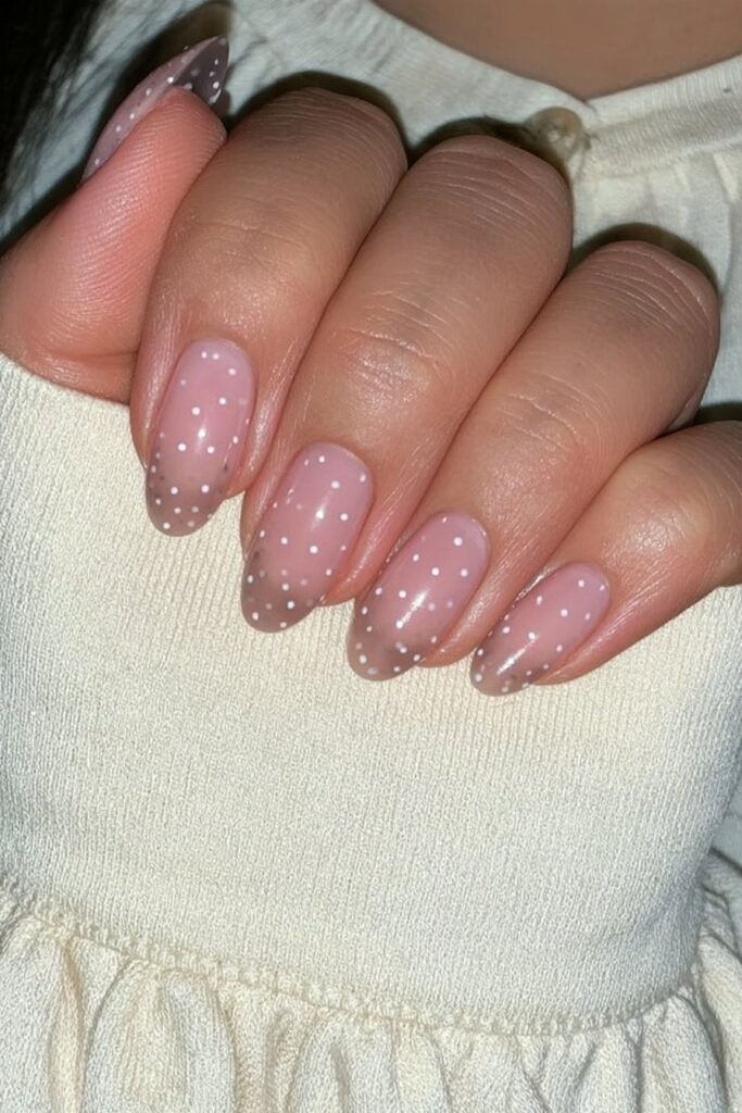 Short sheer sienna nails with tiny white polka dots.
