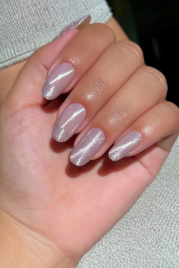 Short round nails in silver velvet with luminous cat-eye reflection.